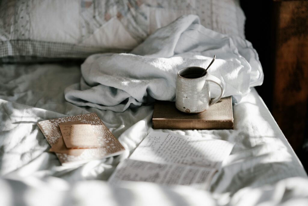 A clean glass mug of warm tea sitting next to a soft linen notebook