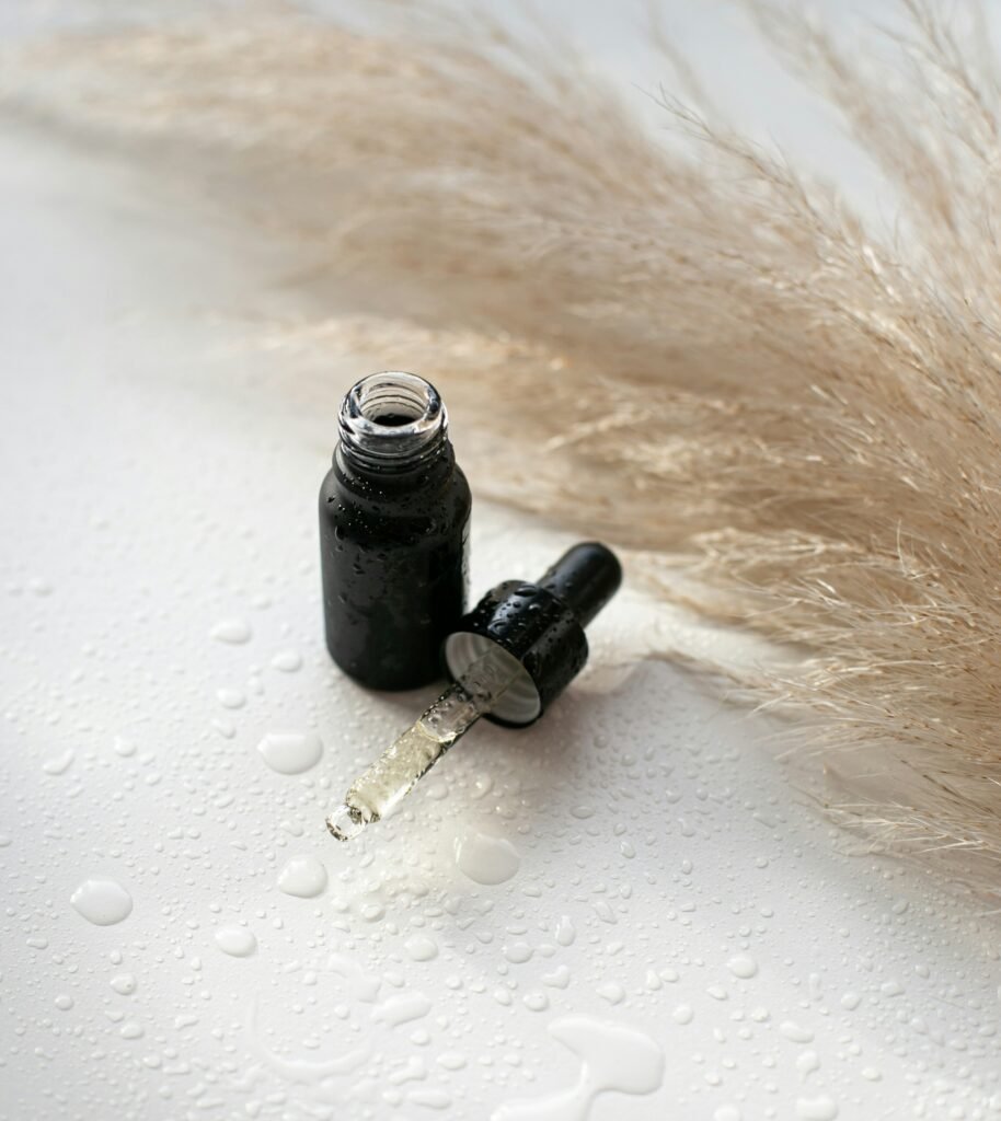 A minimalist glass dropper bottle resting on a folded white cotton bathroom towel