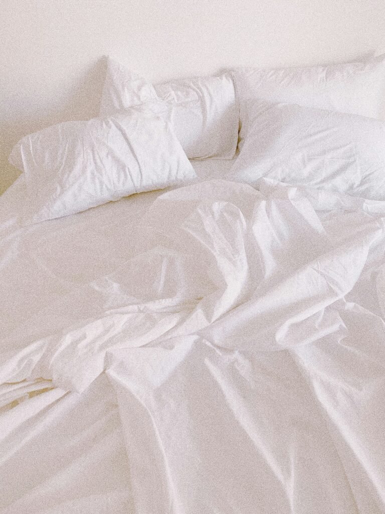 A serene bedroom environment featuring natural breathable fabrics and soft indirect airflow for deep summer sleep