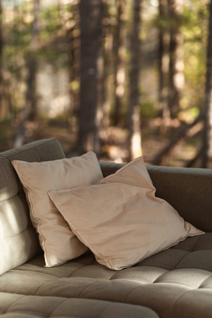 Two warm ceramic mugs placed together on a rustic linen cloth