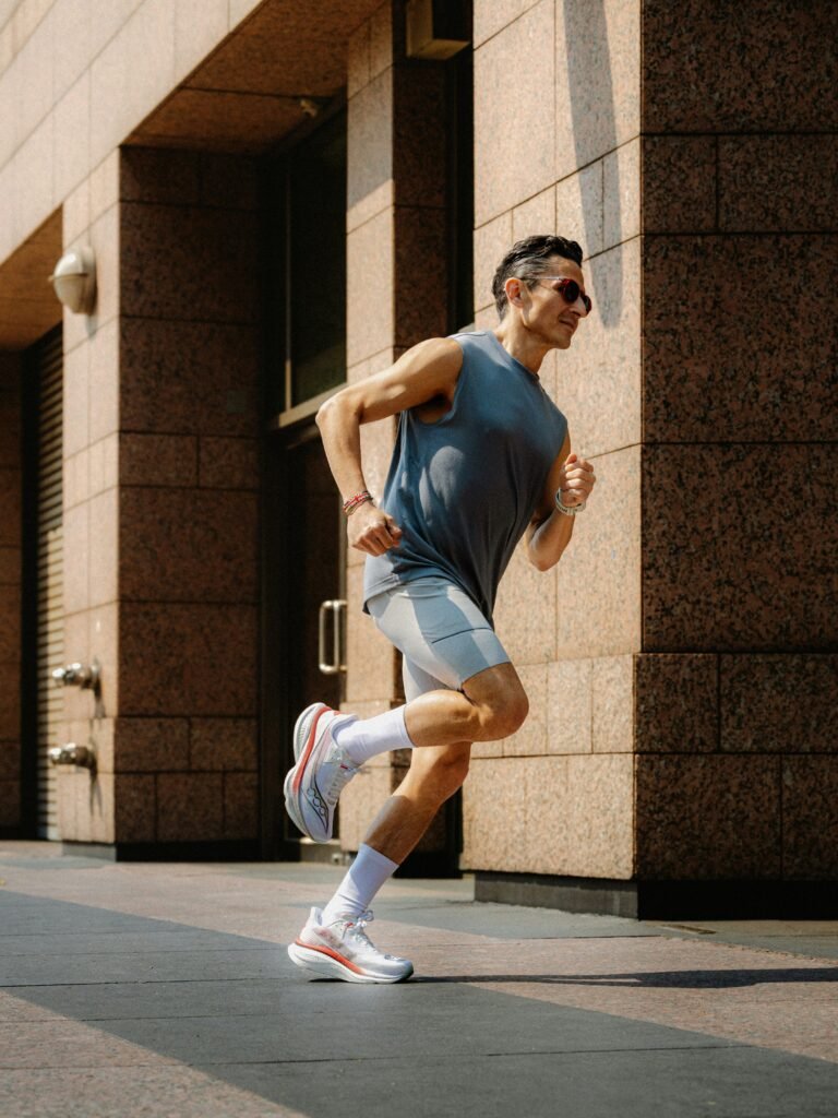 Close up shot of a runner tying shoelaces on a sunlit morning pavement