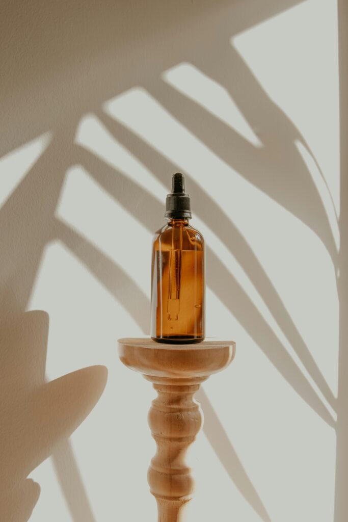 A minimalist hydrating glass dropper bottle resting on a clean white bathroom linen towel
