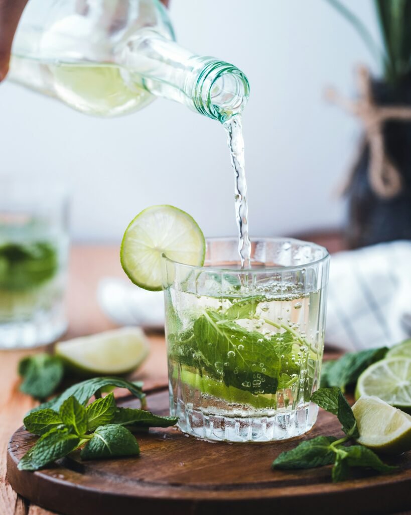 A glass of fresh cucumber lemon water resting on a natural stone outdoor table