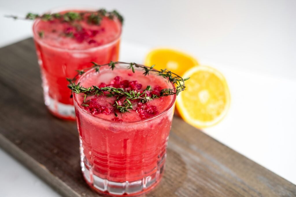 Fresh herbs and citrus slices arranged neatly on a wooden cocktail preparation board