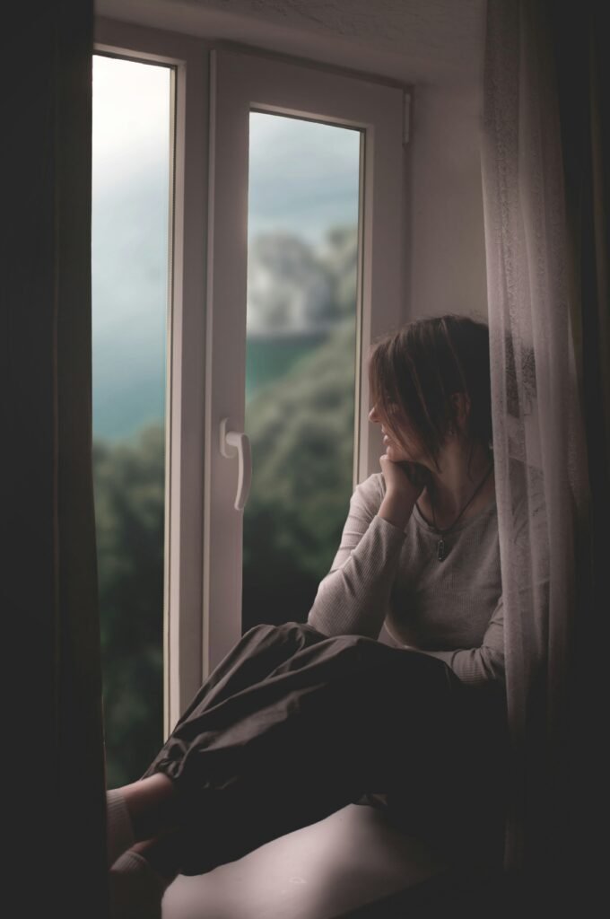 Open window with gentle breeze blowing through sheer white curtains in a peaceful room