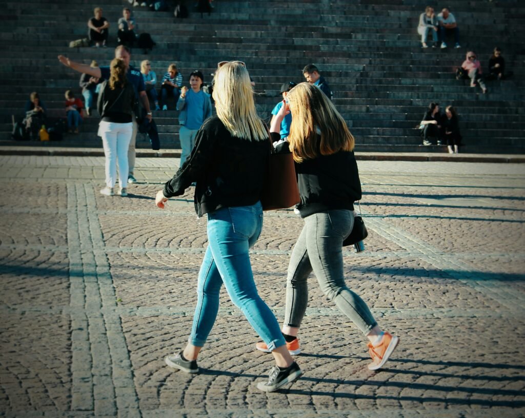 A person walking gently on a sunlit city pavement after an unhurried midday meal